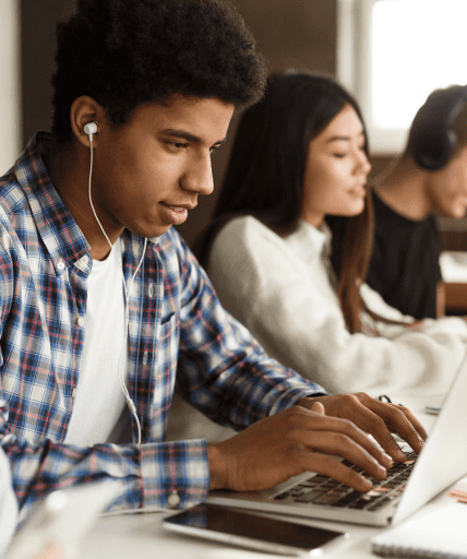 Student listening on earphone while on laptop